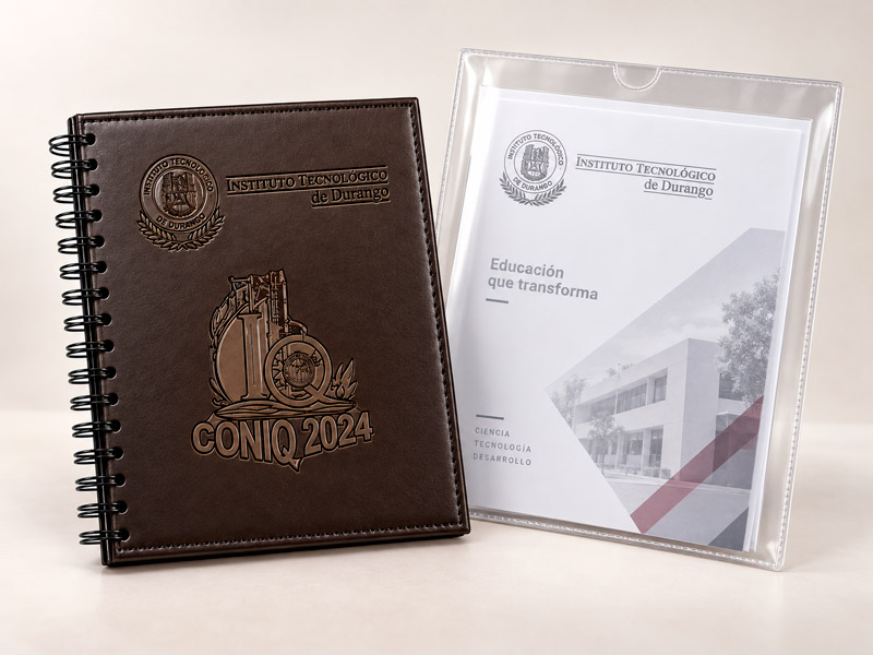 Agenda café con espiral y portada grabada, junto a una mica con documento