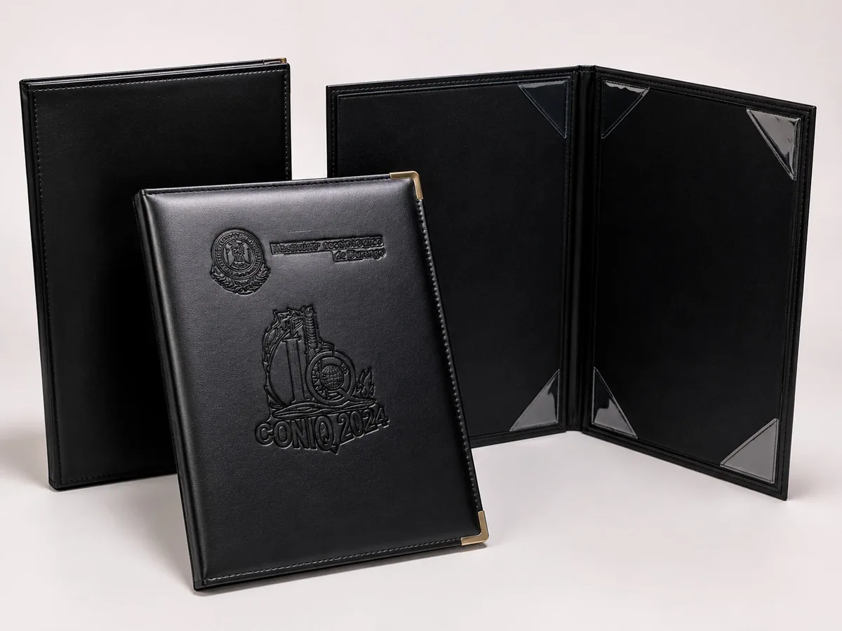 Carpeta negra con escudo grabado en relieve junto a una carpeta abierta