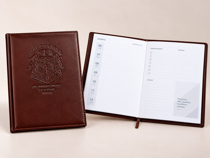 Agenda de piel café abierta con pluma